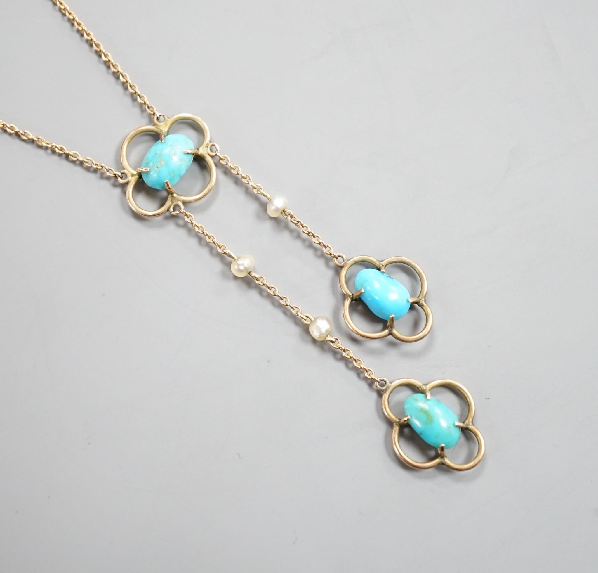 An Edwardian 9ct , three stone turquoise and three stone seed pearl set graduated double drop pendant necklace, 50cm, gross weight 3.1 grams.